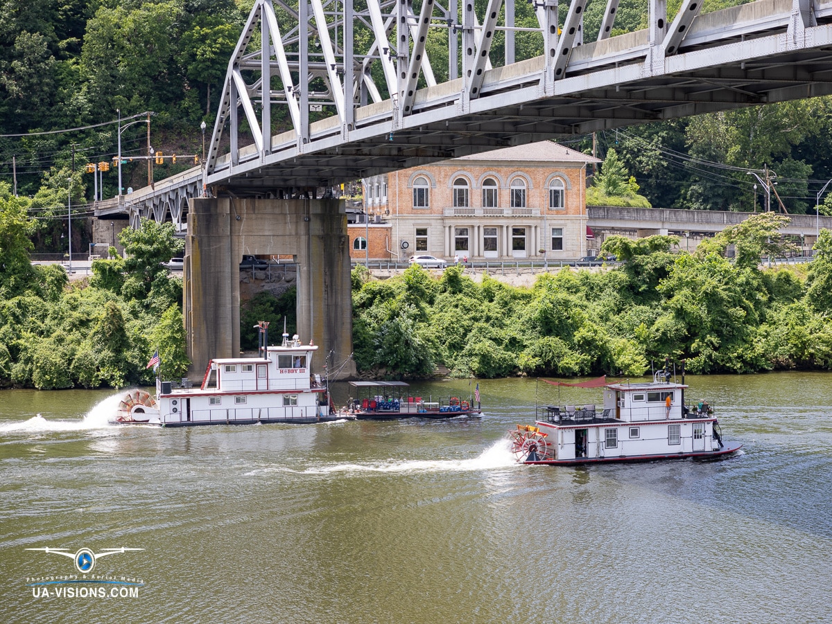 Tugboats passing under a steel bridge on the Kanawha River during the Charleston Sternwheel Regatta 2023.