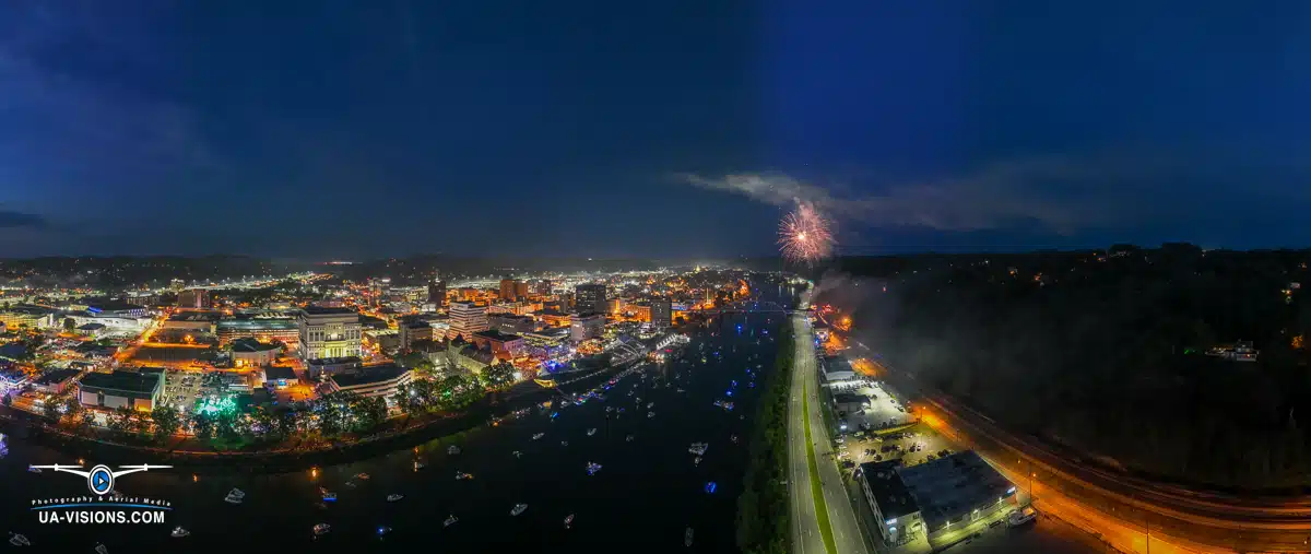 Colorful fireworks explode over the Charleston Sternwheel Regatta, illuminating the river and city skyline.