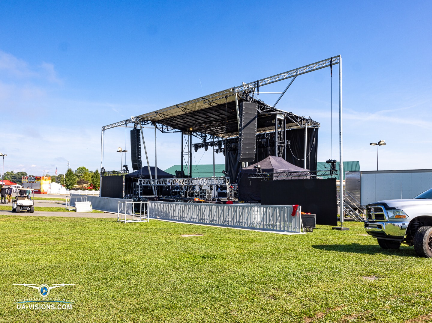 Open-air concert stage setup during daylight at the Healing Appalachia festival in Lewisburg, WV.