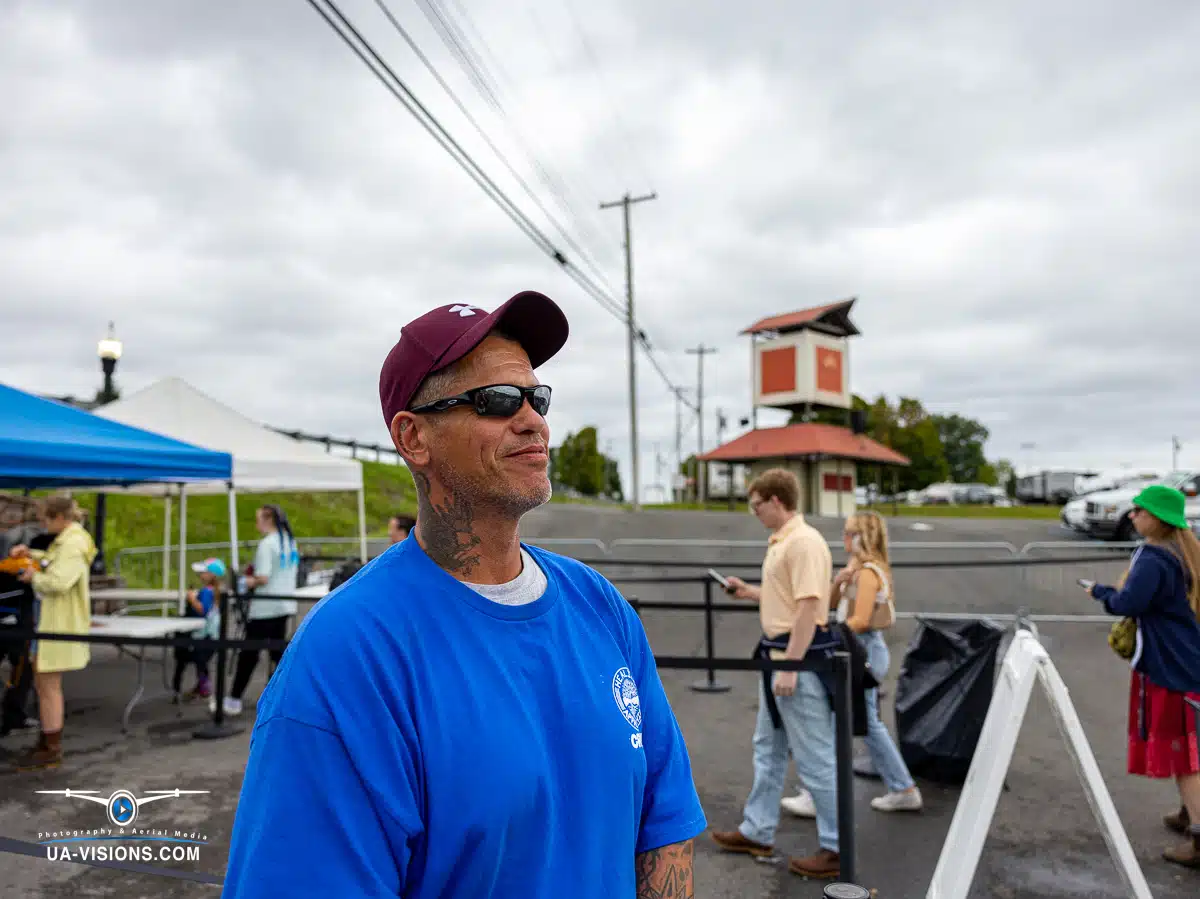 Volunteer in a blue shirt smiling warmly at the Healing Appalachia event.