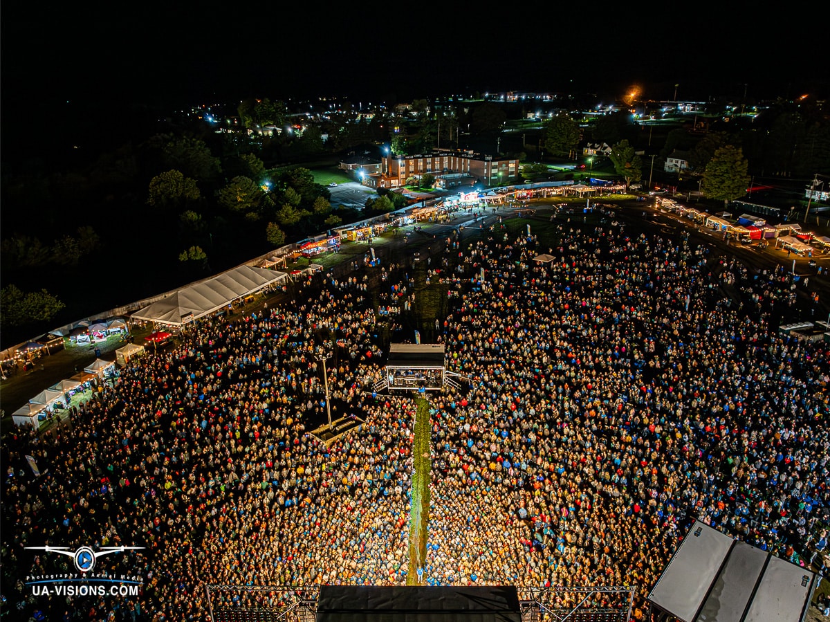 Aerial night shot of Healing Appalachia festival showing crowd density and stage setup.