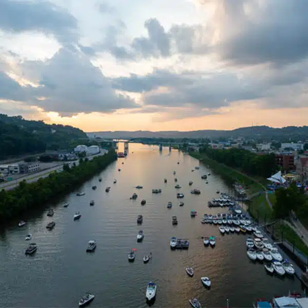 Aerial view of boats lined up on the Kanawha River during the 2023 Charleston Regatta at sunset.