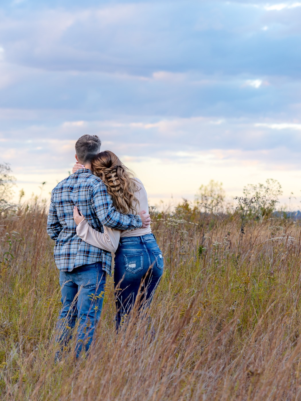 Kaitlyn and Logan sharing a tender moment amidst Charleston's golden fields during their engagement photo session.
