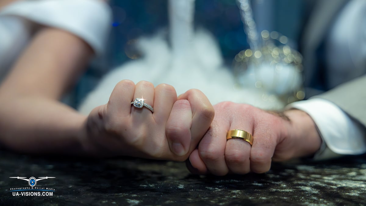 Close-up of a newlywed couple's hands with their wedding rings.