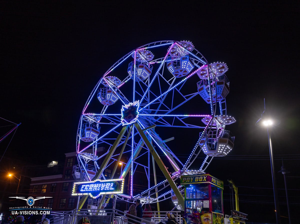 UA-Visions presents the Ferris wheel at Charleston's Light the Night, a neon spectacle in the night, symbolizing joyous heights of holiday spirit and the art of professional event photography.