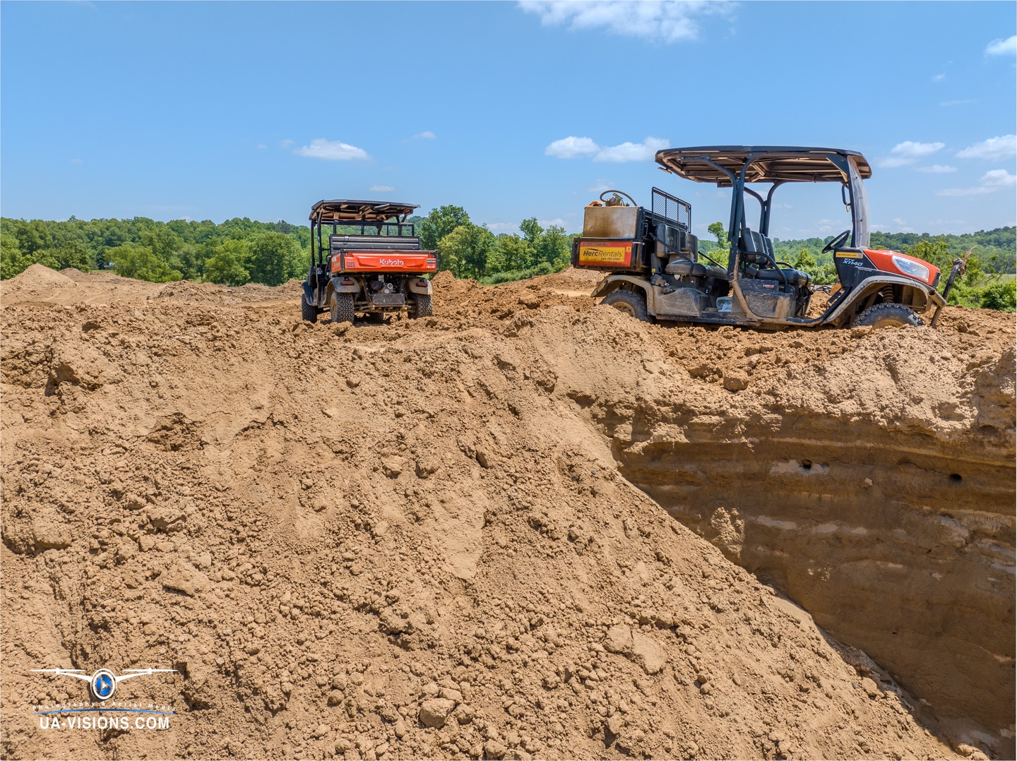 UA-Visions captures a moment of solitude with a Kubota perched atop a mound, shaping Ashton's landscape.
