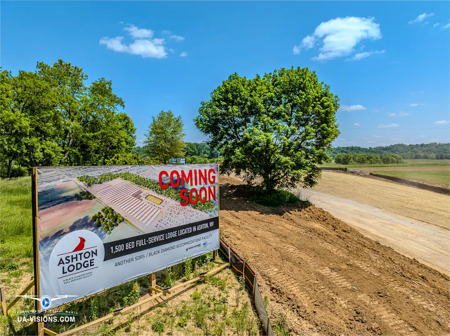 A billboard announcing the future site of Ashton Lodge amidst an active construction landscape, by UA-Visions.