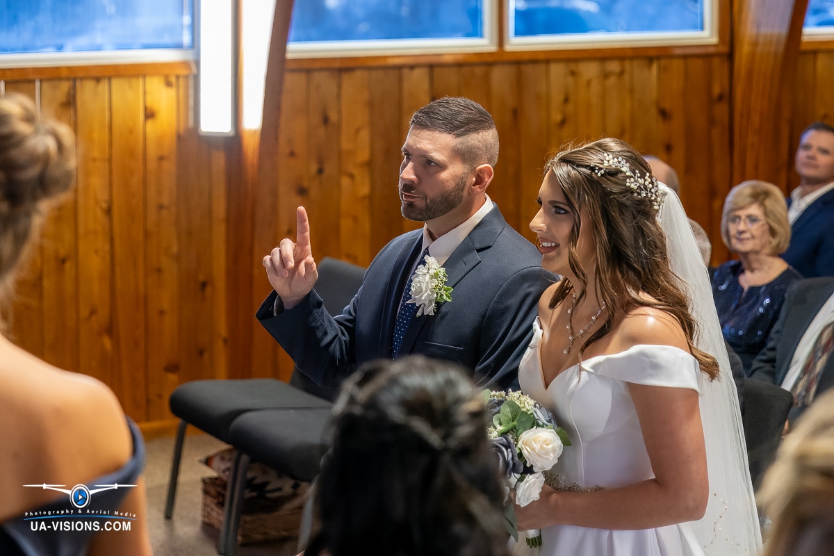 Father of the bride raises his hand in a meaningful gesture as he gives her away during the wedding ceremony in Hurricane, WV.