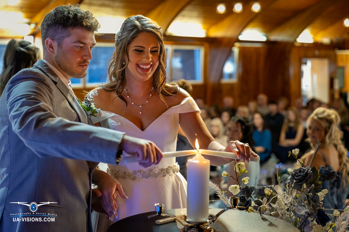 Bride and groom smiling as they light the unity candle, symbolizing their new bond in Hurricane, WV.