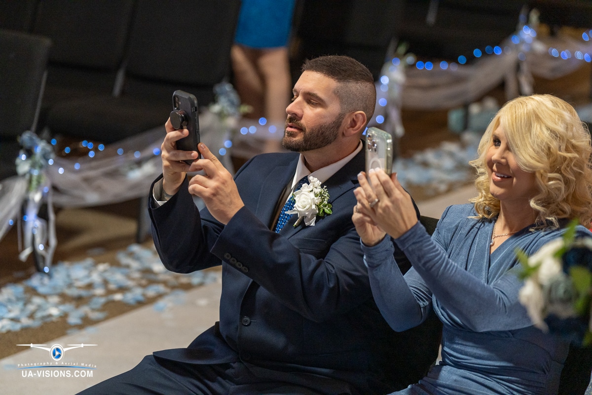 The Bride's parents excitedly capture the ceremony on their smartphones in Hurricane, WV.