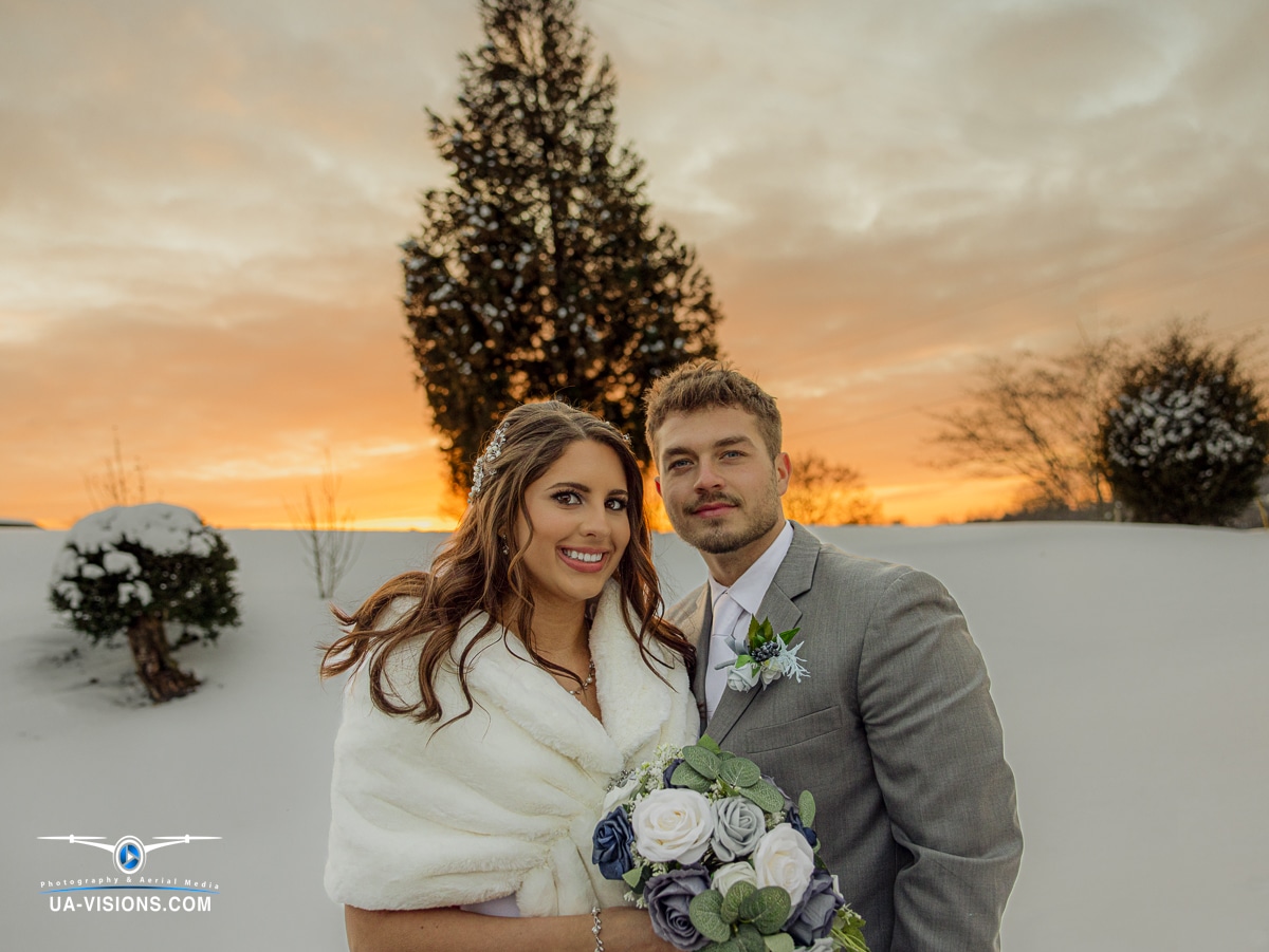 Katilyn and Logan Gaddy smile radiantly against the backdrop of a snowy sunset.