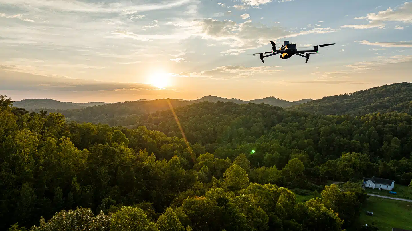 Drone Photos: Aerial drone capturing sunset over the lush greenery of West Virginia's hills, showcasing UA-Visions' aerial photography services.