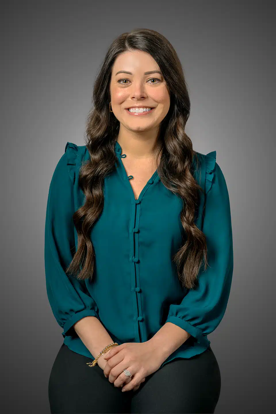 Professional headshot of a businesswoman with a friendly demeanor, wearing a teal blouse