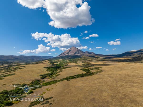 An epic sweep of Colorado's plains leading up to the grand finale of a mountain peak under a dramatic sky